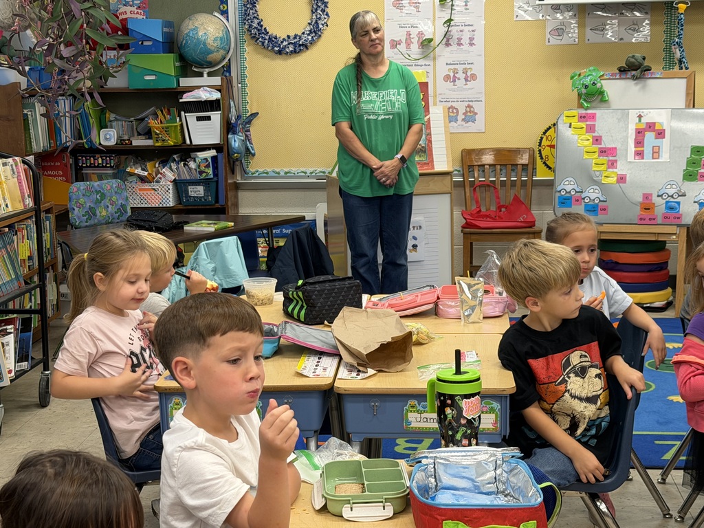 Mrs. Judy's kindergarten/first grade combo class eats lunch as Mrs.Orr, the Librarian at the Wakefield Public Library, and her Assistant, Mrs.Weir, reads to them.