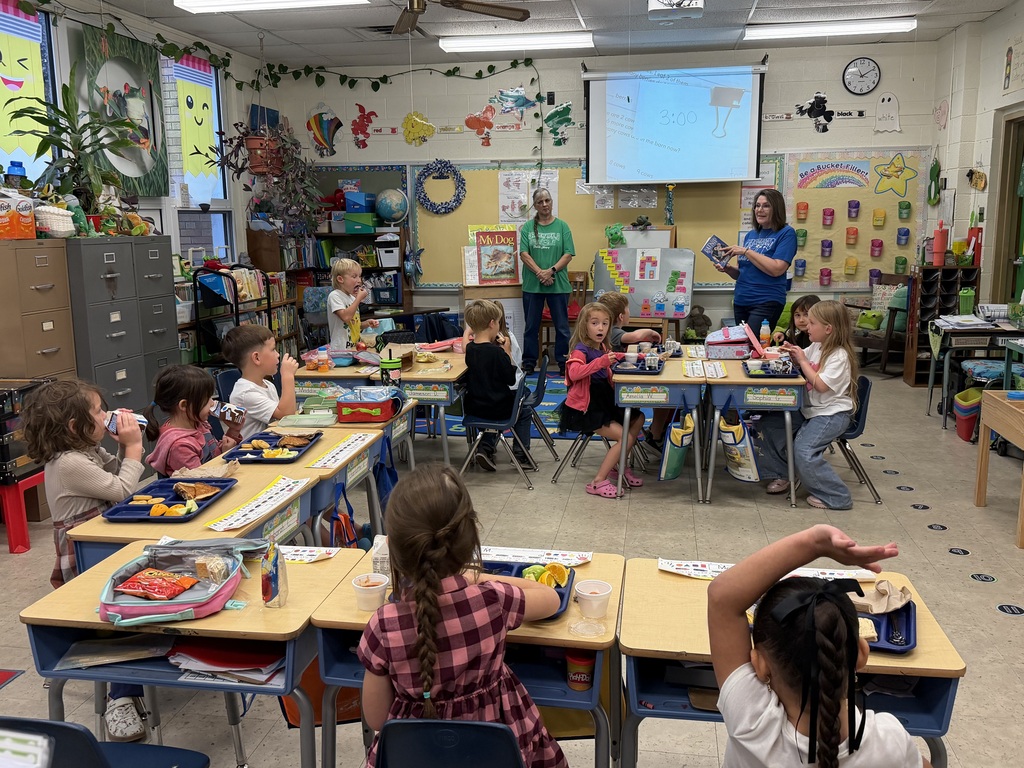 Mrs. Judy's kindergarten/first grade combo class eats lunch as Mrs.Orr, the Librarian at the Wakefield Public Library, and her Assistant, Mrs.Weir, reads to them.