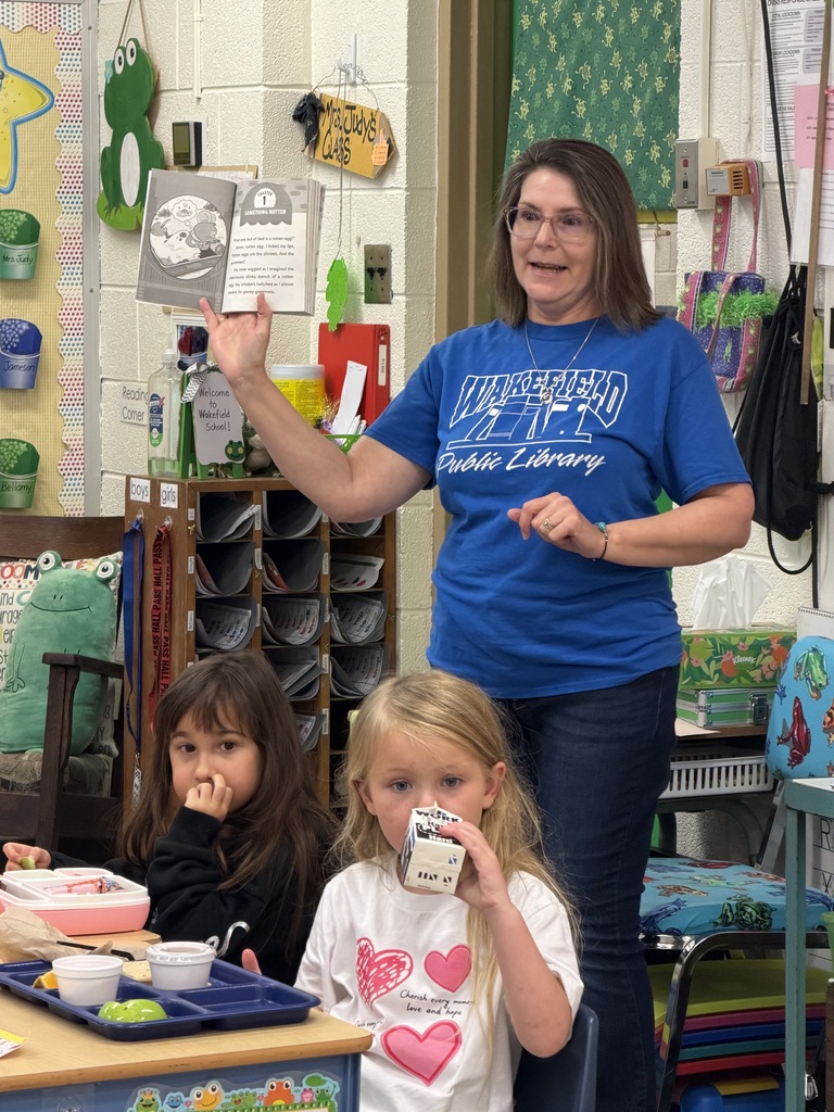 Mrs. Judy's kindergarten/first grade combo class eats lunch as Mrs.Orr, the Librarian at the Wakefield Public Library, and her Assistant, Mrs.Weir, reads to them.