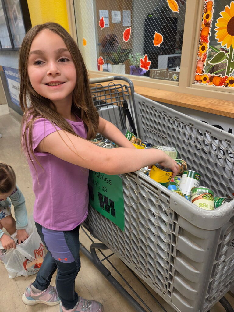 Mrs. Shannon's class helps stock grocery carts for the "V is for Vegetables" food drive. All items will go to the Lighthouse.