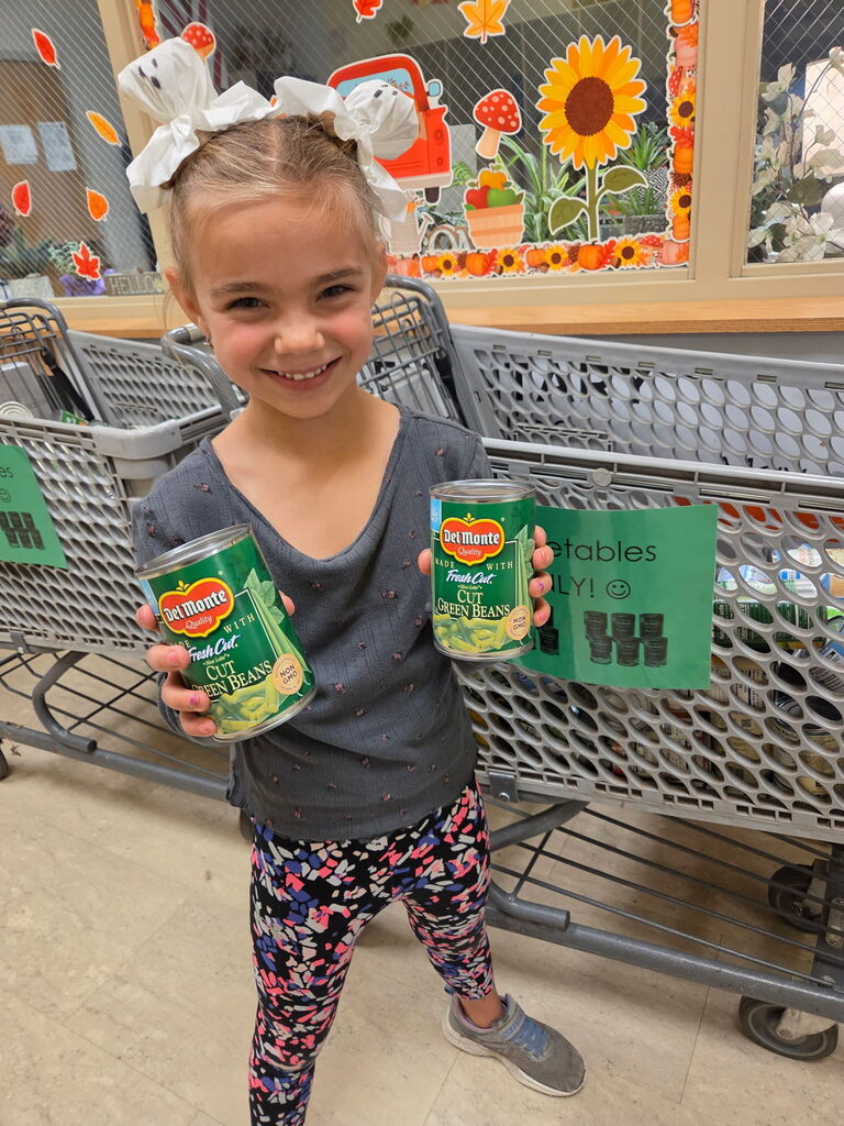 Flyer titled “Vv is for Vegetables!” announcing a canned vegetable drive at Lincoln Elementary School, September 29–October 2. Mrs. Shannon’s Friends of the Lighthouse Service Project invites Lincoln Cubs to fill grocery carts with canned vegetables only. All donations benefit Lighthouse for Christ to support families in the Clay Center community. The flyer celebrates completing ABC Bootcamp and features cans of peas, corn, and green beans.