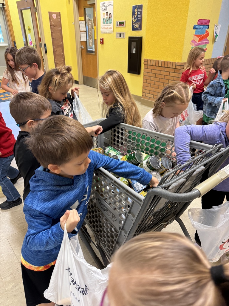 Mrs. Shannon’s kindergarten students sack and load all of the canned vegetables collected from their recent food drive.