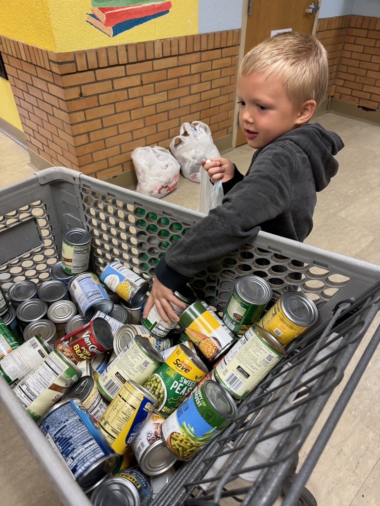 Mrs. Shannon’s kindergarten students sack and load all of the canned vegetables collected from their recent food drive.