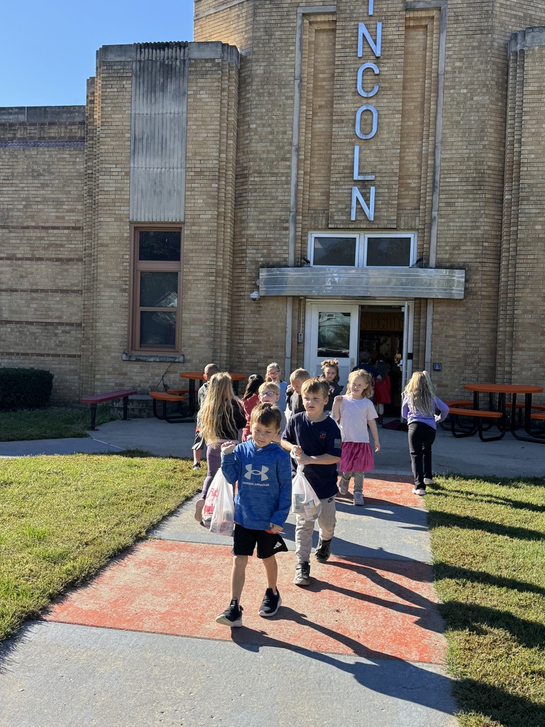 Mrs. Shannon’s kindergarten students sack and load all of the canned vegetables collected from their recent food drive.