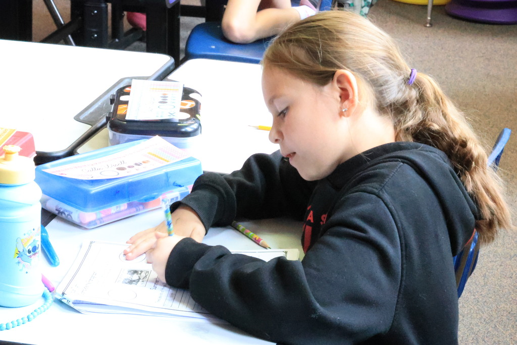 Mrs. Ringering helps her 2nd graders write a paragraph describing summer activities.