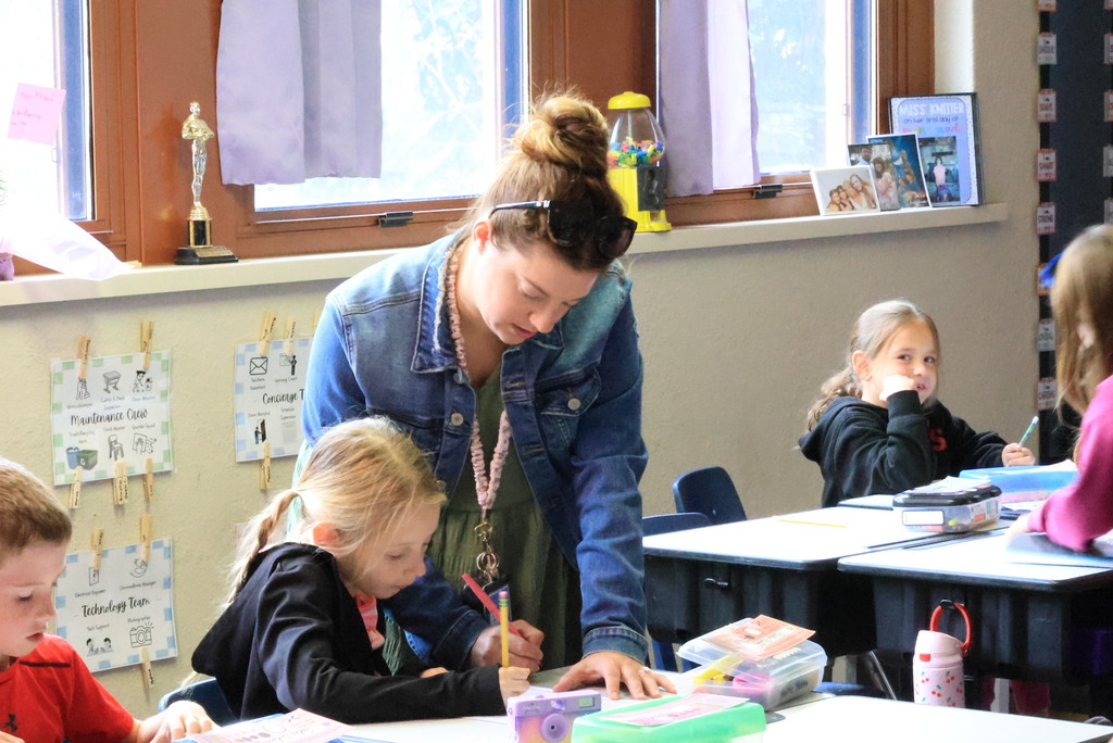 Mrs. Ringering helps her 2nd graders write a paragraph describing summer activities.