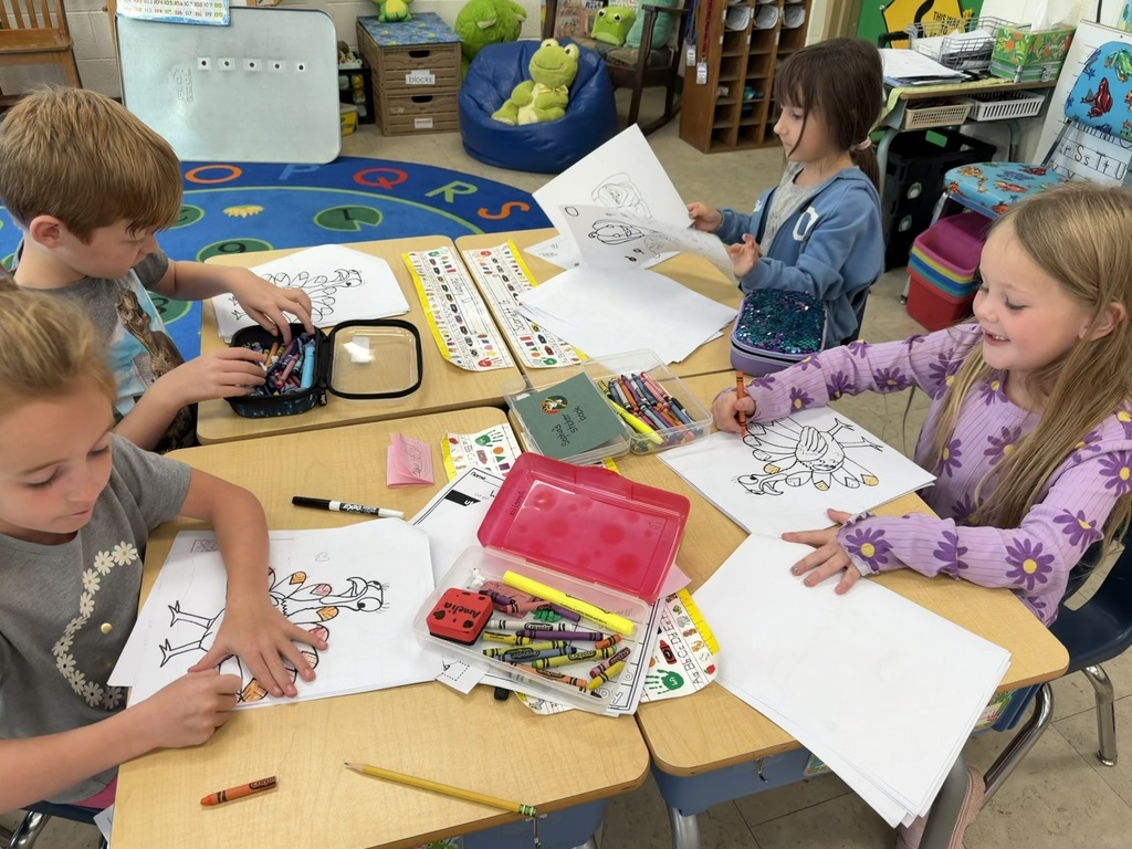 The K-1 class colors in their new art books created by the middle and high school art students.