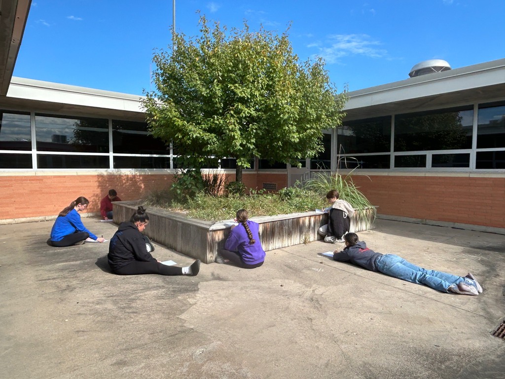 Mrs. Artman's Drawing/Painting class sits outside in the CCCHS commons while continuing to learn to draw contour lines. 