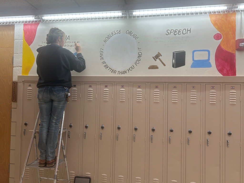 Scouten Baker, an advanced art student for Mrs. Artman, works on a new mural outside Mrs. Blackburn's room at CCCHS. The mural theme is Speech and Debate.