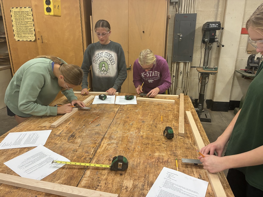 Mrs. Schooley's industrial arts students measure and cut boards.