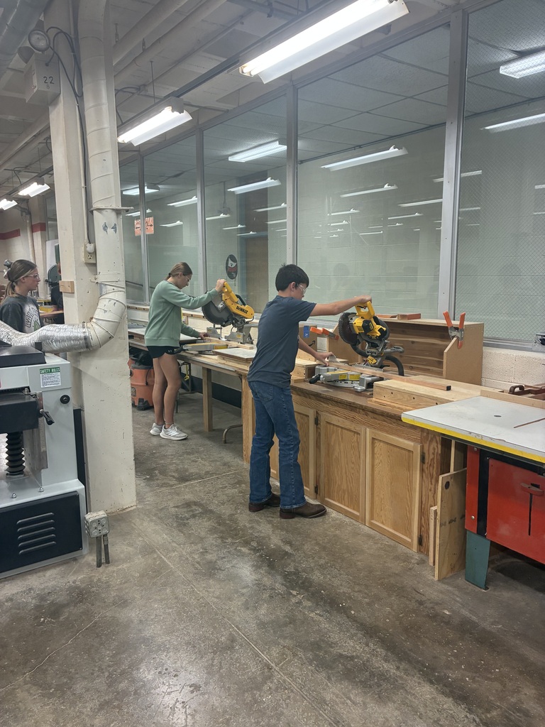 Mrs. Schooley's industrial arts students measure and cut boards.