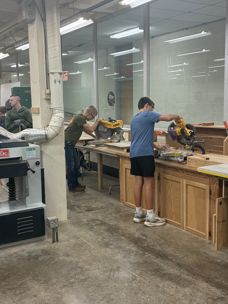 Mrs. Schooley's industrial arts students measure and cut boards.