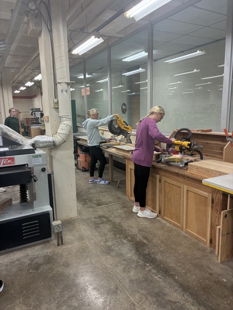 Mrs. Schooley's industrial arts students measure and cut boards.
