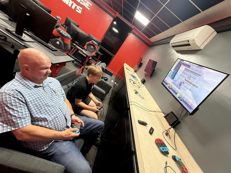 SRO and student playing video game in esports room.