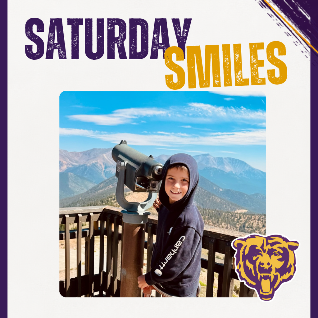 Saturday Smile featuring a student smiliing in front of mountains looking through a telescope. 