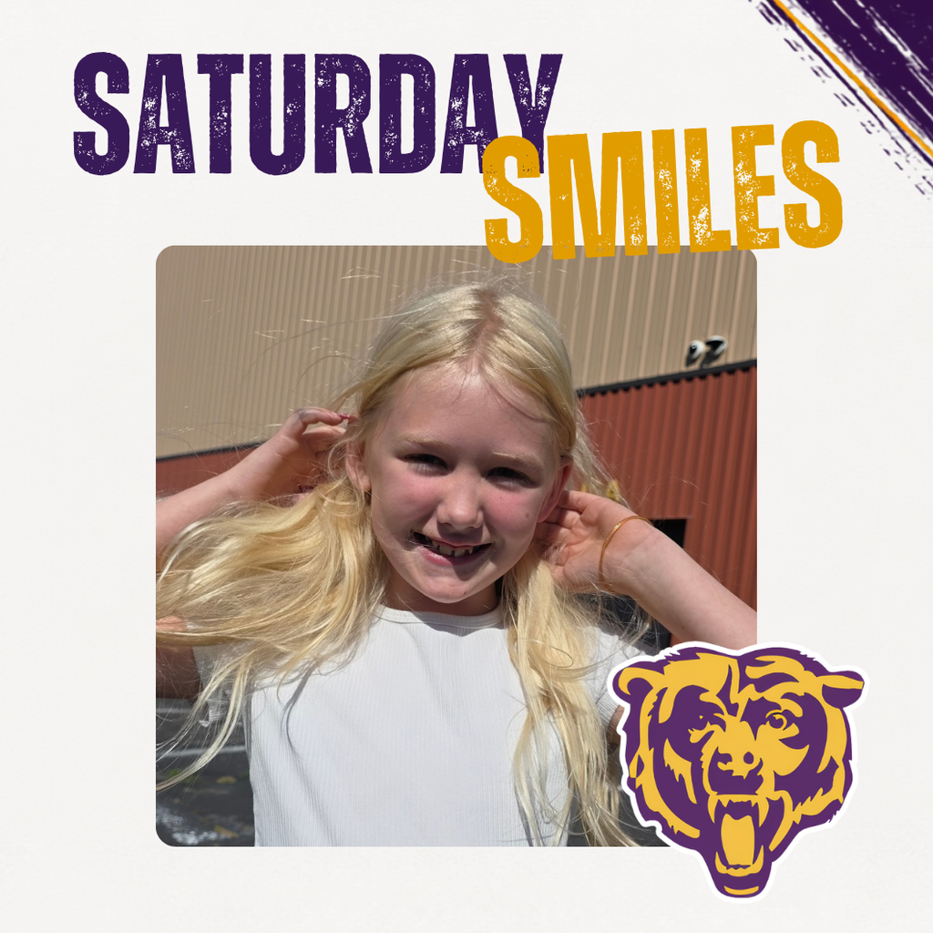 Saturday Smiles Post with a student smiling in front of the school.