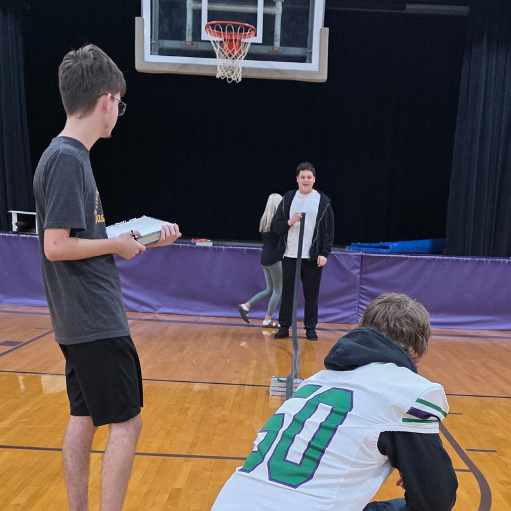 Students standing in a gym testing speed on a ramp.