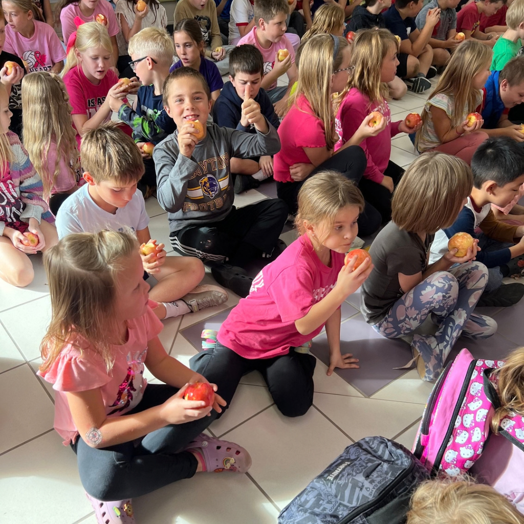 The great apple Crunch with student in a lobby eating apples.