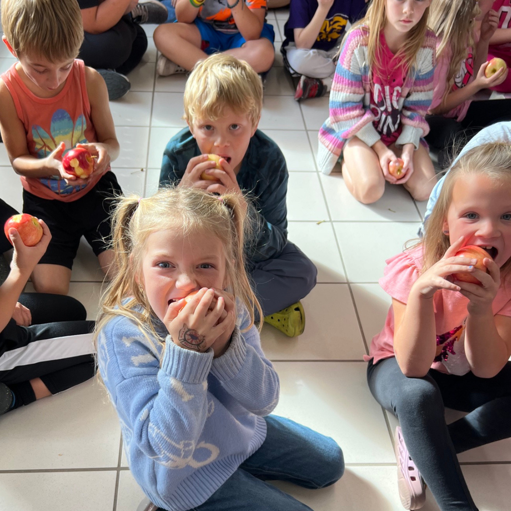 The great apple Crunch with student in a lobby eating apples.