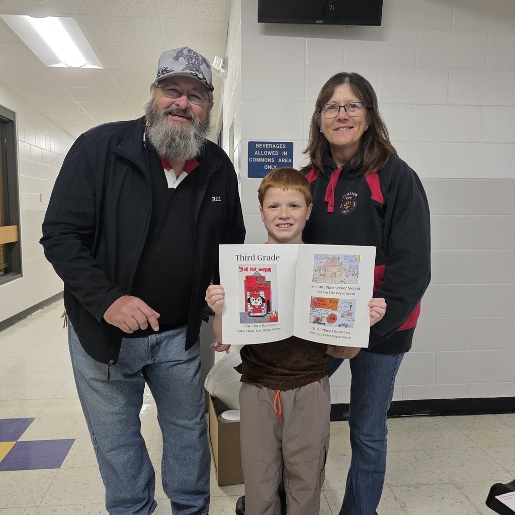 Three people posting with a fire safety poster book
