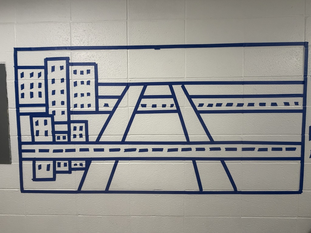 Artwork on a wall of the school made with blue tape. 