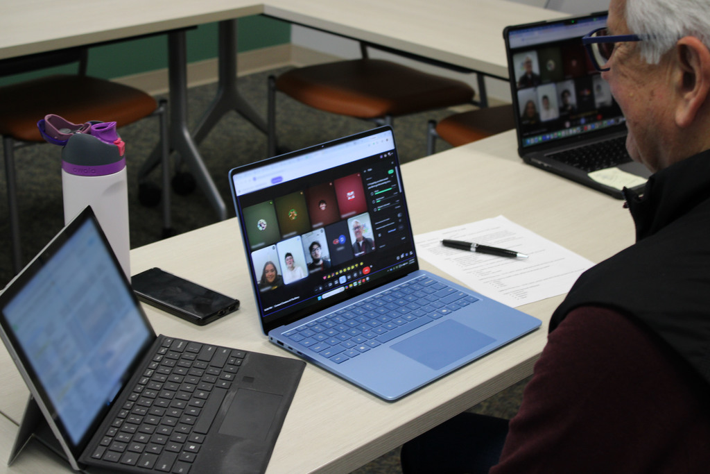 Bob Pautke's laptop on the desk in the conference room displaying the students in the Content Creators meeting.