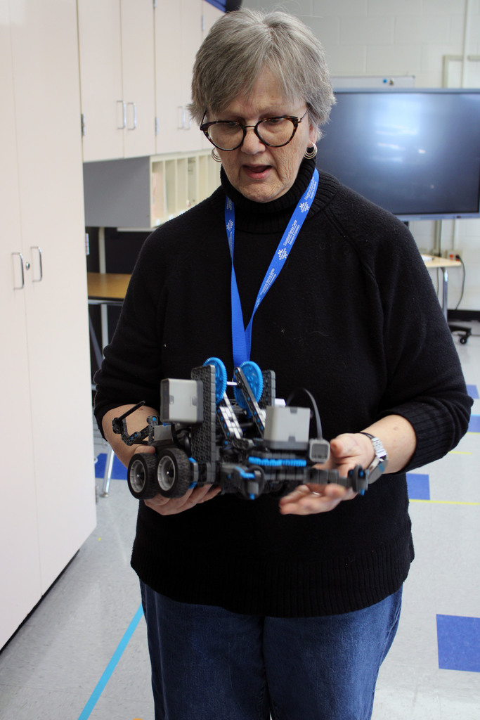 Teacher explaining how the VEX robot works to parents.