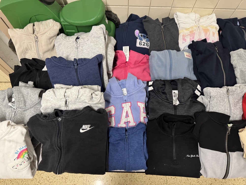 Twenty sweatshirts and a green toy tractor in lost and found
