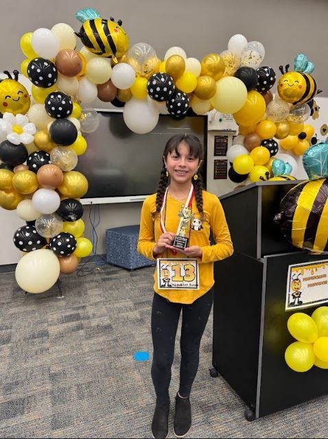 Spelling Bee winner holding her award