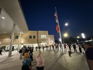 Student gathering at the flag pole to show  togetherness.
