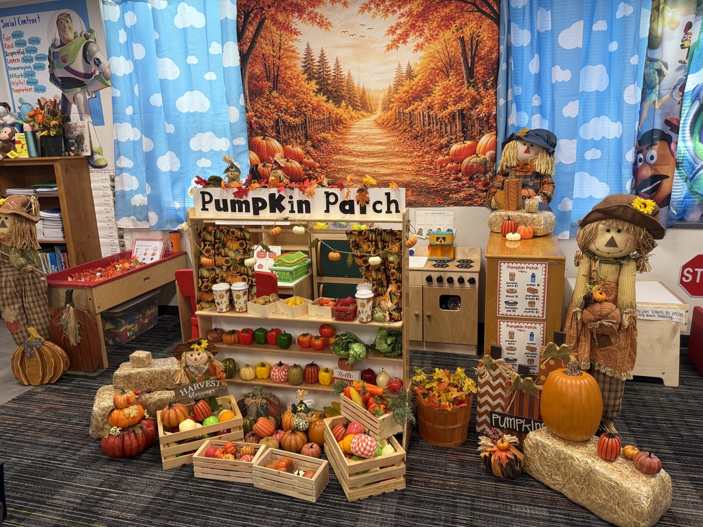 Decorated classroom with an autumn theme. Pumpkins, harvest decorations, and a play market table with various produce.