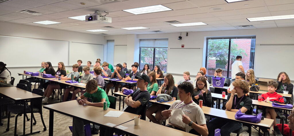 Students in a classroom listening and watching a presentation