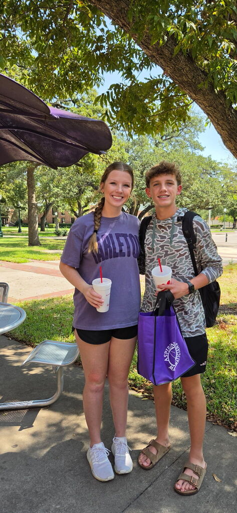 Two people standing by one another posing for a photo.