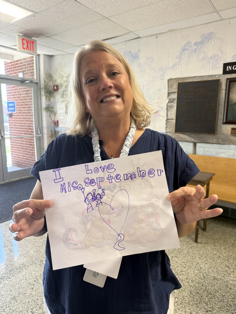 Mrs. Swanner holding up a student note that says “I Love Mrs. September!” 