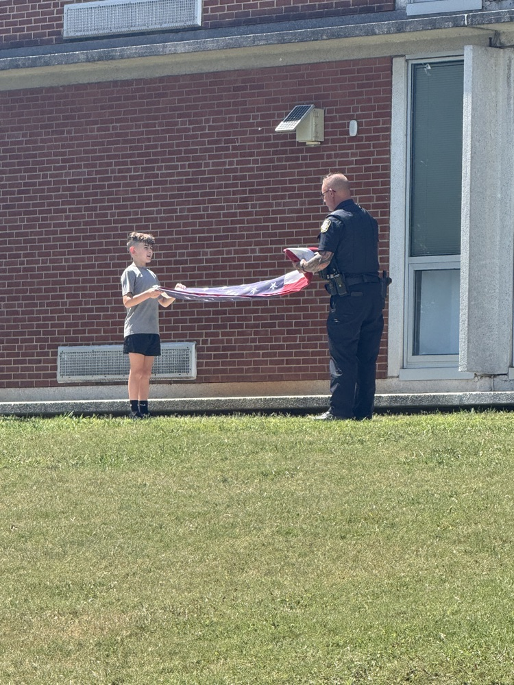 SRO helping student fold the American flag