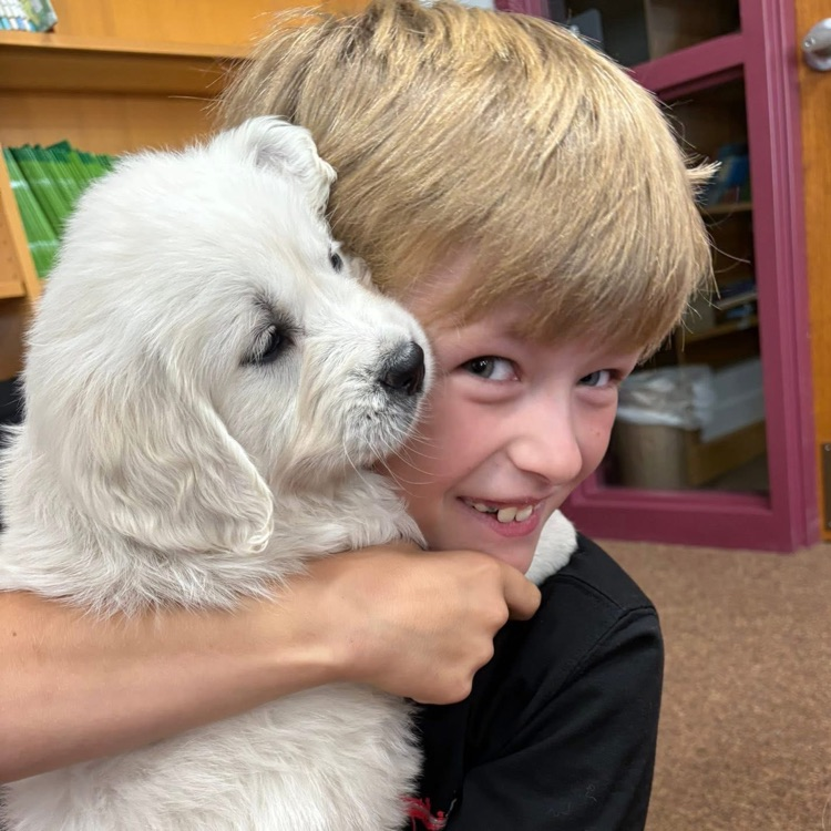 student cuddling puppy 