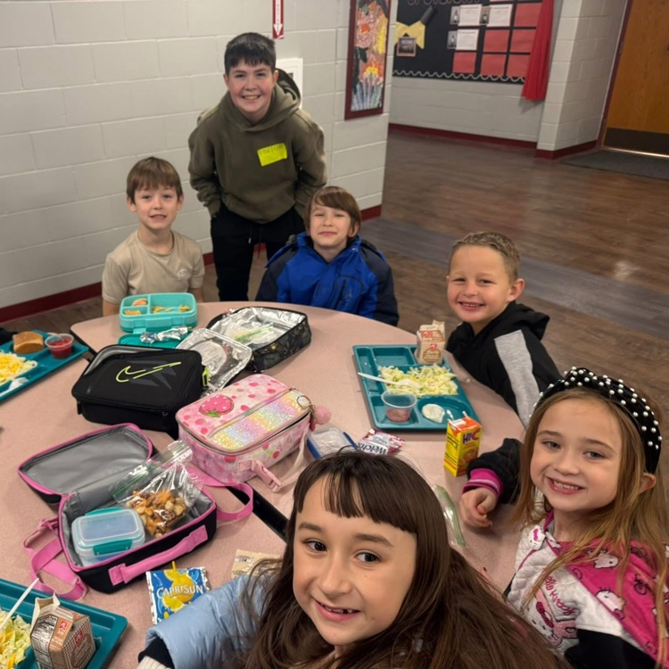 high school student with elementary at lunch