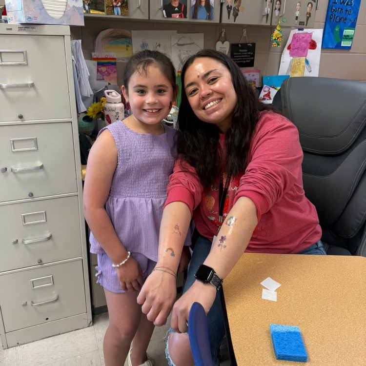 student and staff showing off tattoo
