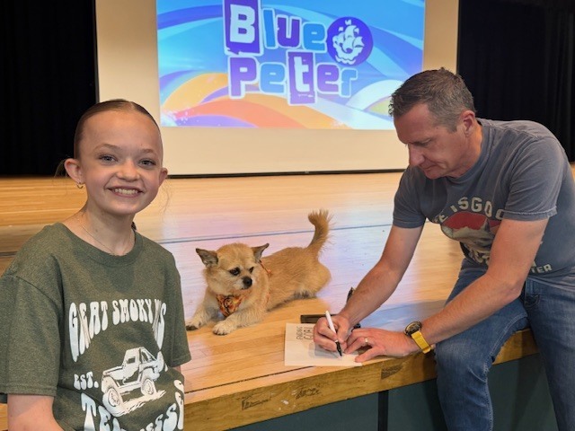 Photo of Gobi the Dog, aurthor Dion Leonard, and a Middle School Student