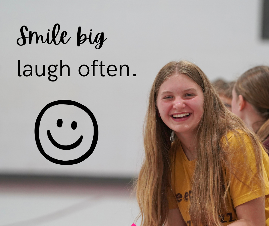 Student smiling with a monday motivation saying of Smile Big. Laugh Often.