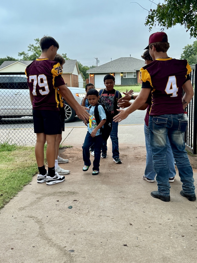 Members of the CHS Football Team greeting students at SW.