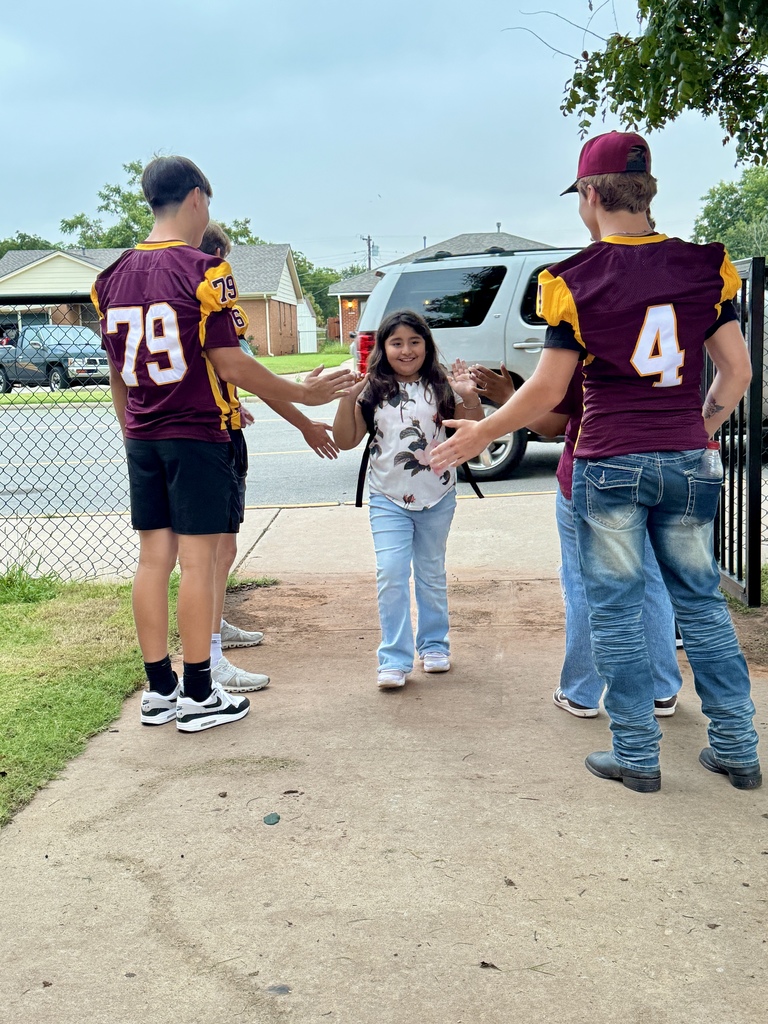 Members of the CHS Football Team greeting students at SW.