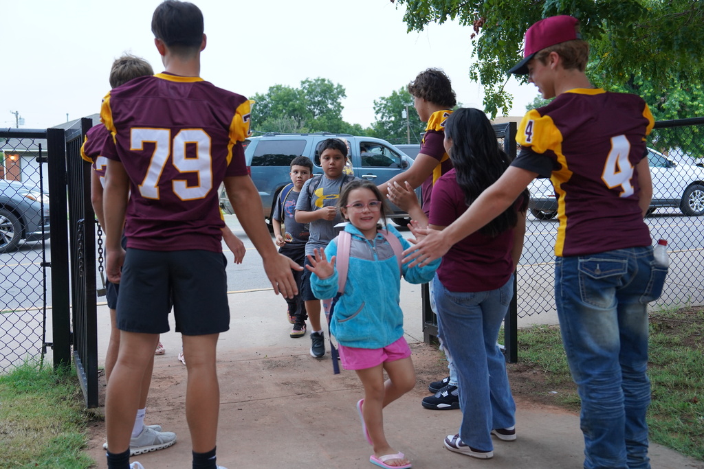 Members of the CHS Football Team greeting students at SW.