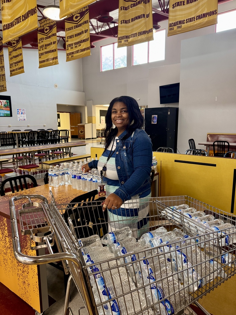 Mrs. Hurd loading water bottles in a grocery cart.