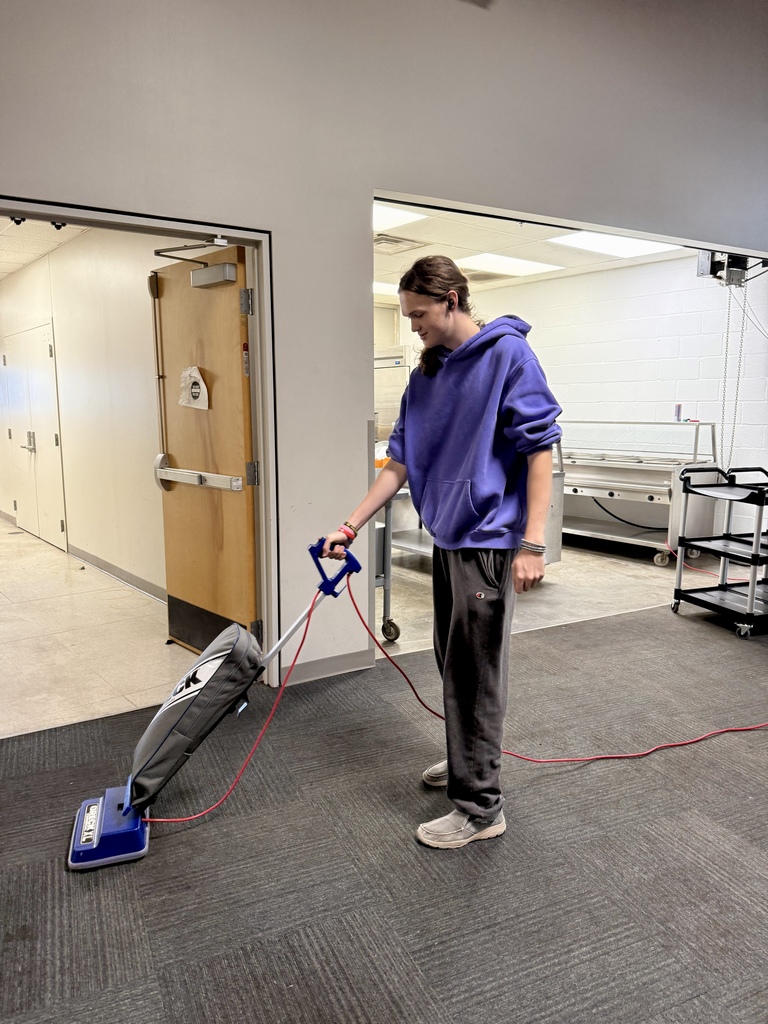 Senior Capstone students sweeping the floor at the Frisco Center.