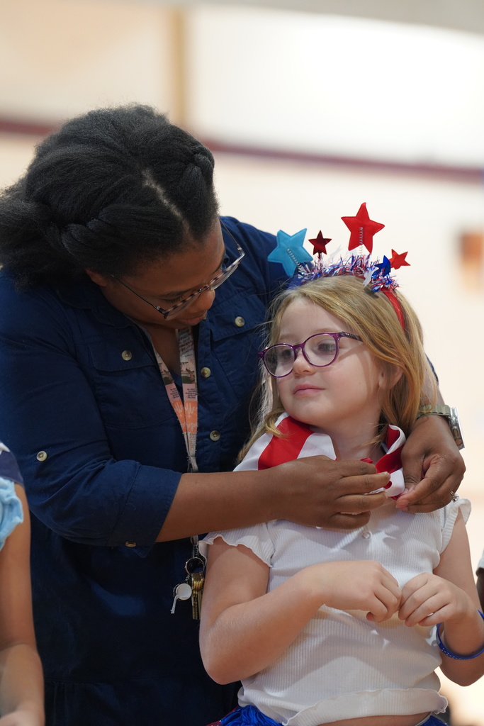 Mrs. Jefferson tying a bandana on a student