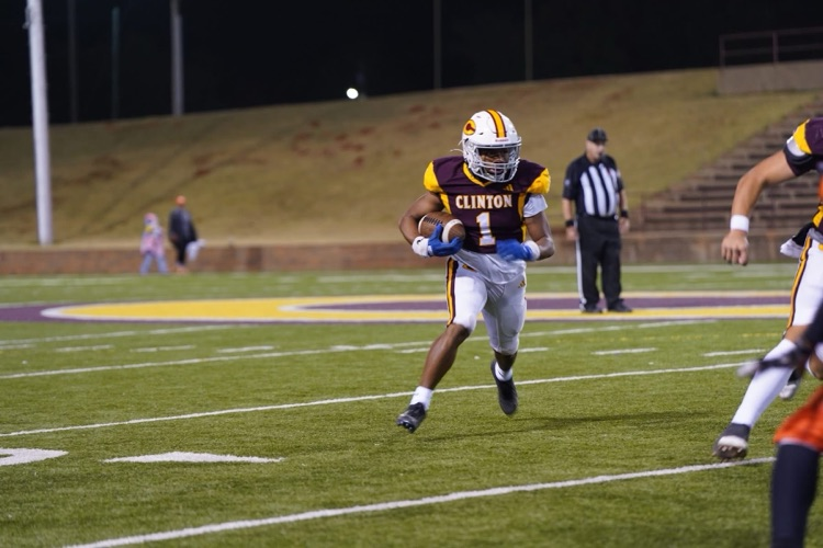 Senior football player running with the football