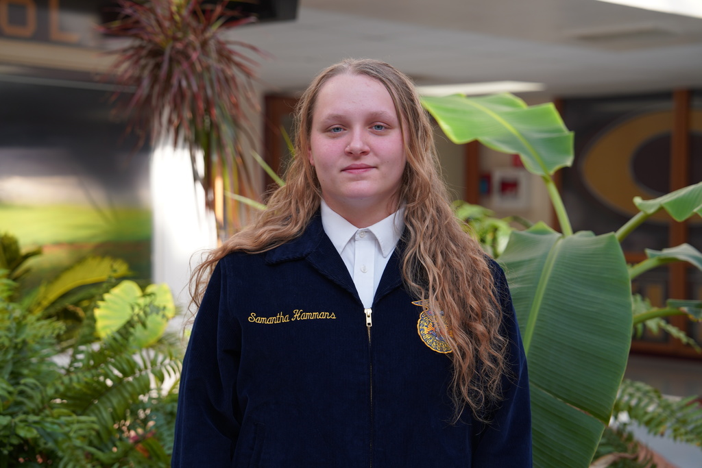 State FFA degree candidate in front of plants