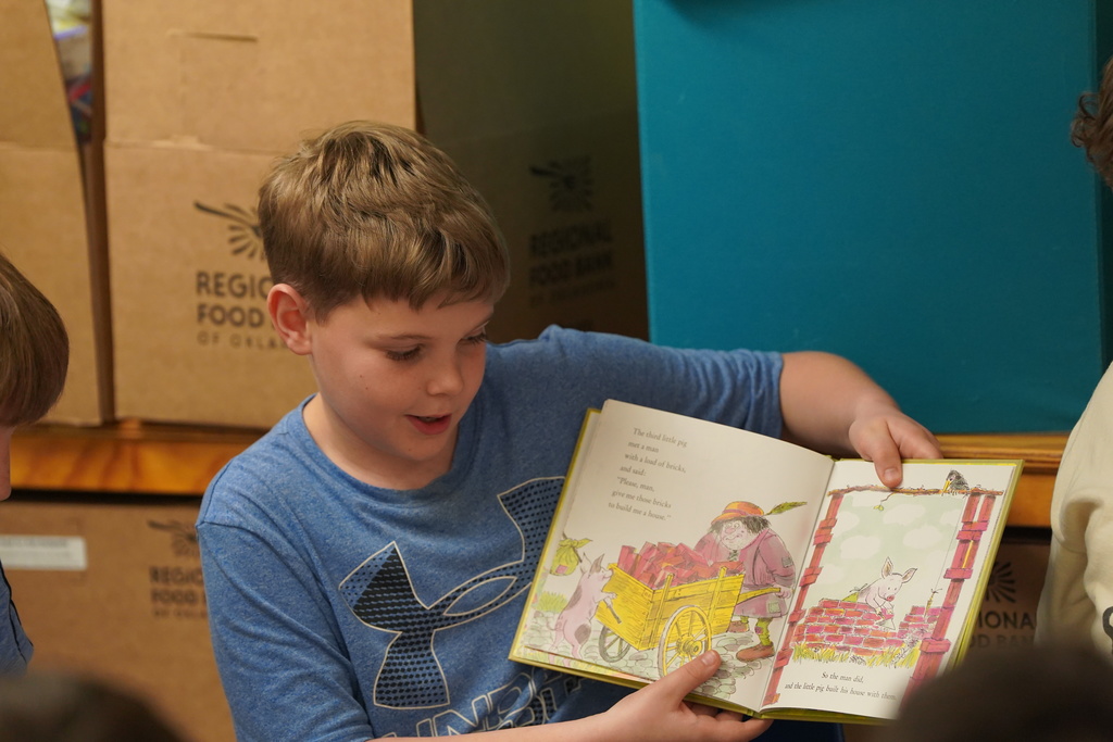 GT student reading book to a group of Nance students