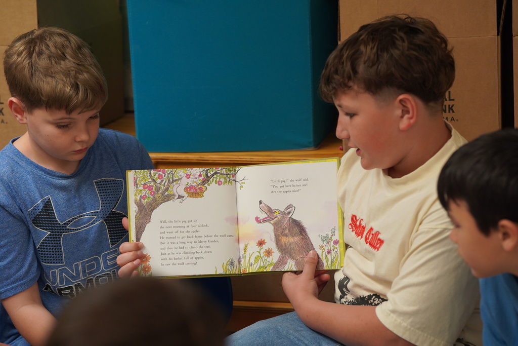 GT student reading a book to the boys group